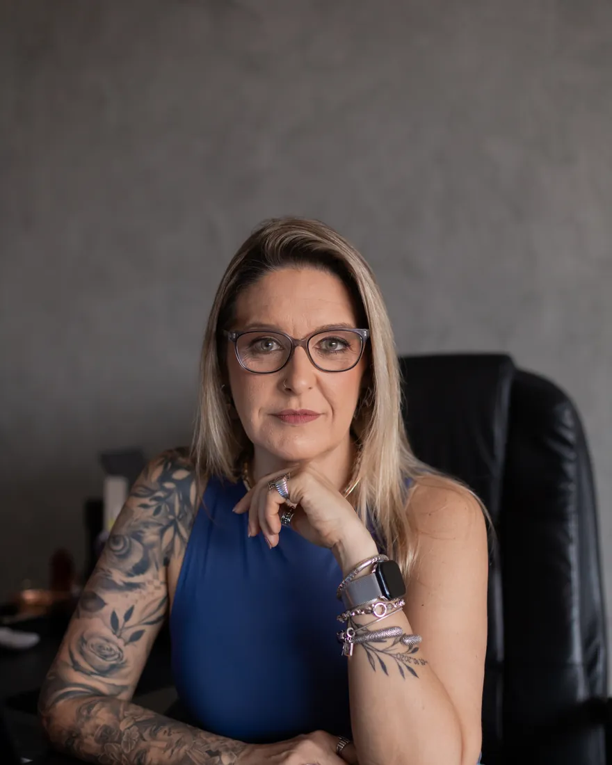 Renatta Höher no escritório, apoiada na mesa