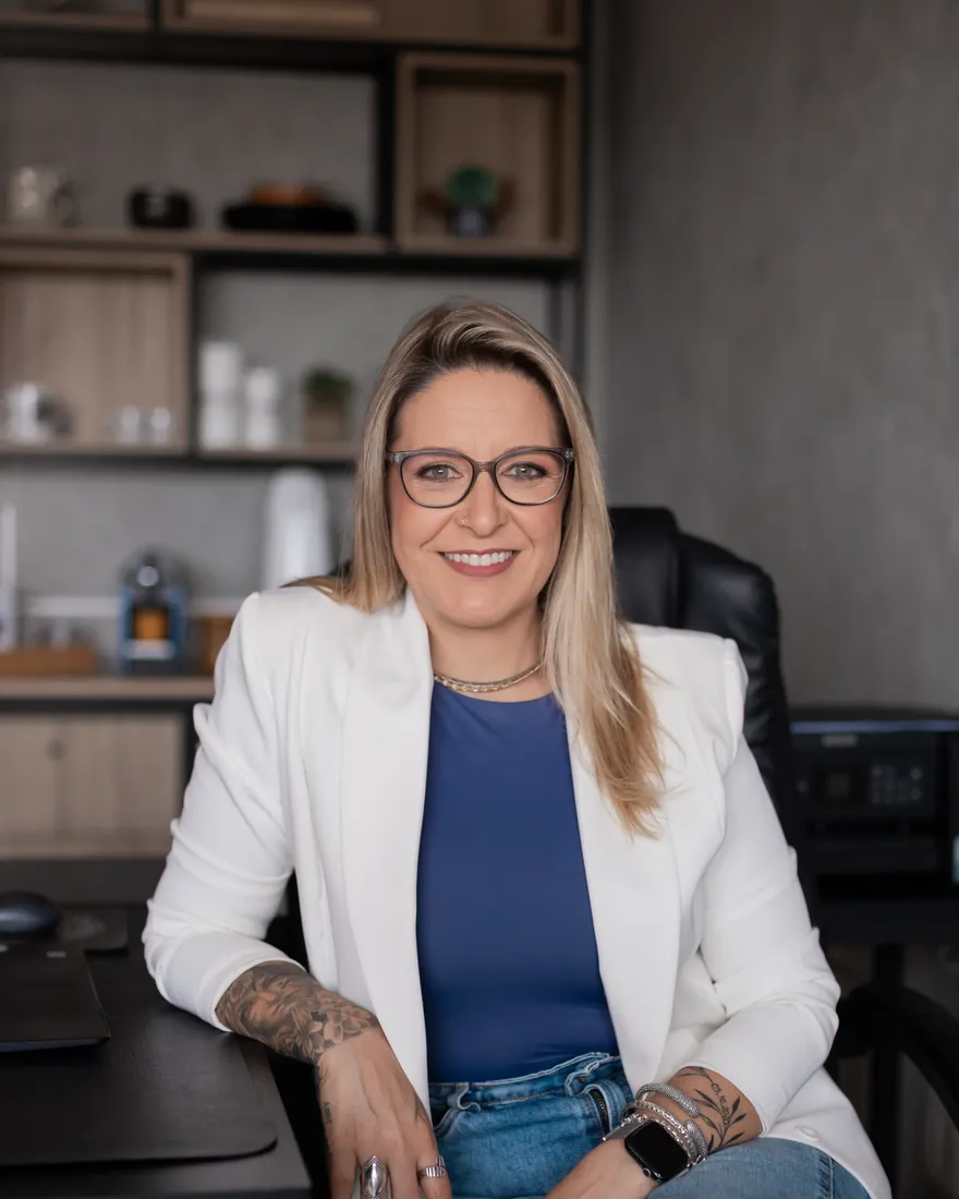 Renatta Höher sentada no escritório, sorrindo